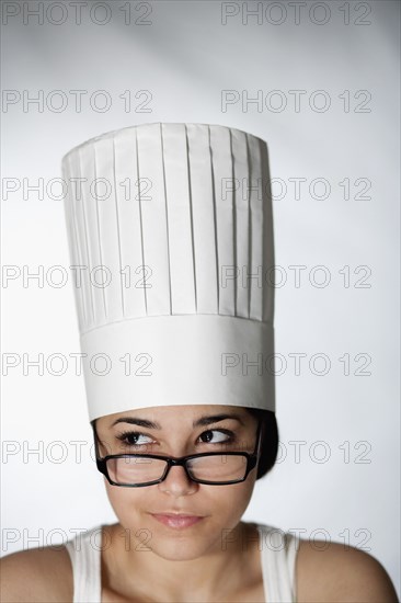 Hispanic woman in chef's hat and eyeglasses