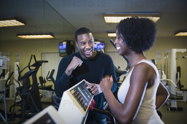 Personal trainer motivating woman on treadmill