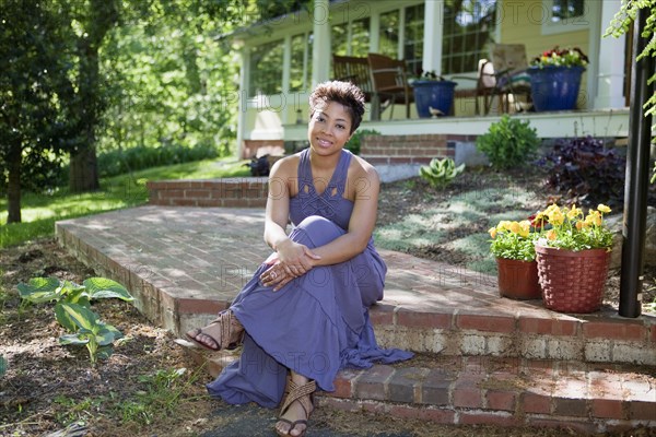 Black woman sitting on step in back yard