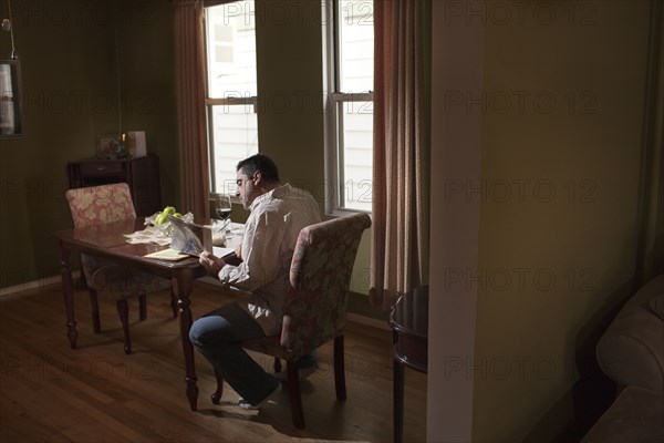 Caucasian man having dinner and reading