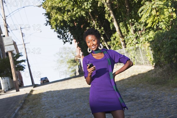 African American woman text messaging on cell phone outdoors