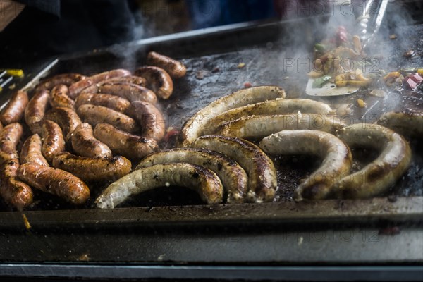 Links of meat cooking on grille