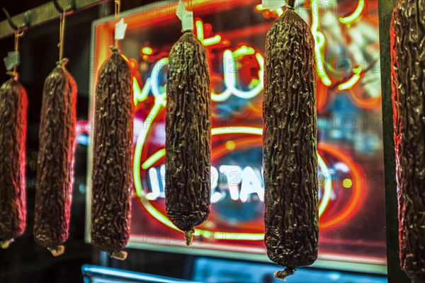 Dried meat handing near neon sign