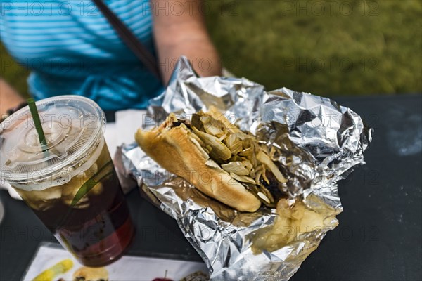 Woman holding hot dog and soda with ice