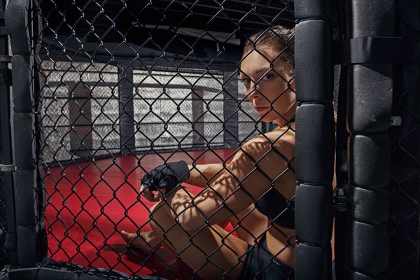 Caucasian fighter sitting in ring