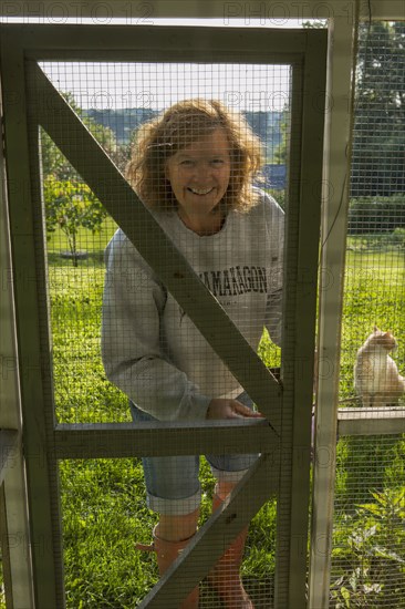 Caucasian woman standing near chicken coop