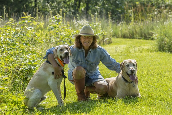 Caucasian woman petting dogs in garden