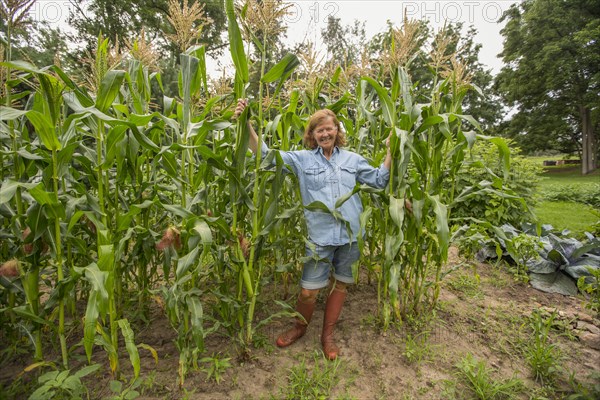 Older Caucasian woman standing in corn field on farm