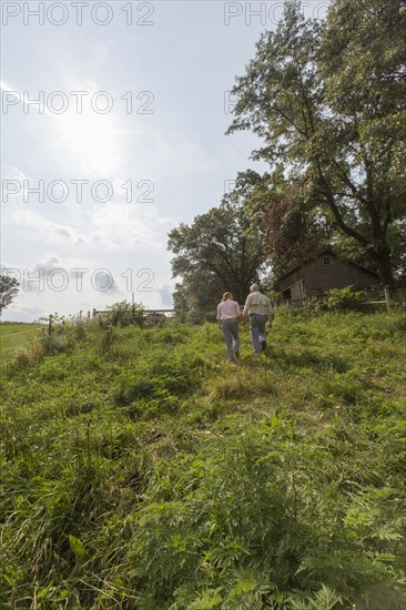 Older Caucasian couple walking on farm