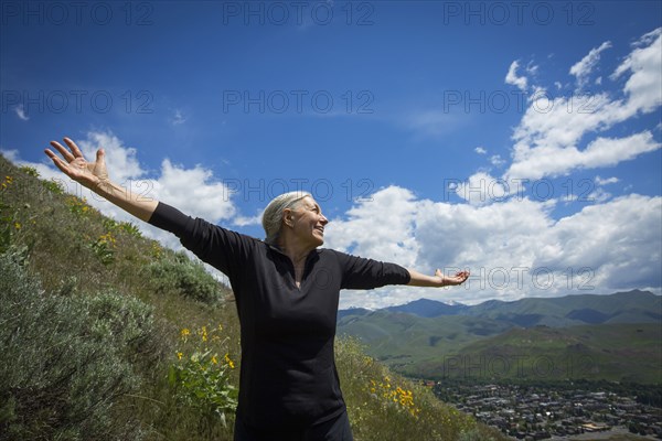 Caucasian woman cheering on rural hillside