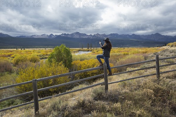 Caucasian woman photographing rural river