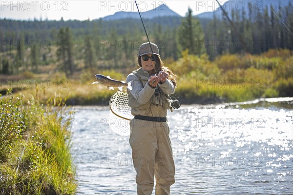 Caucasian woman fishing in rural river