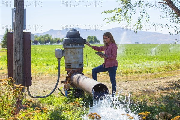 Caucasian farmer checking water pump