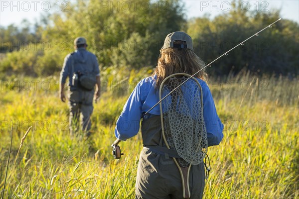 Caucasian couple with fishing gear in field