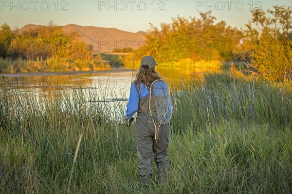 Caucasian woman with fishing gear at river