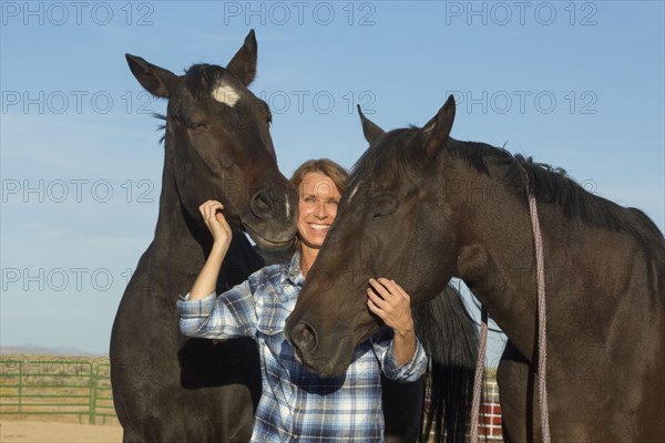 Caucasian rancher smiling with horses