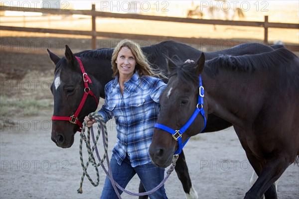 Caucasian rancher walking horses