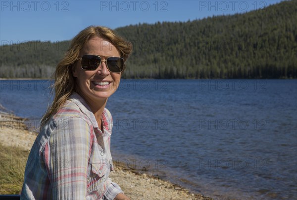 Caucasian woman sitting at remote lake