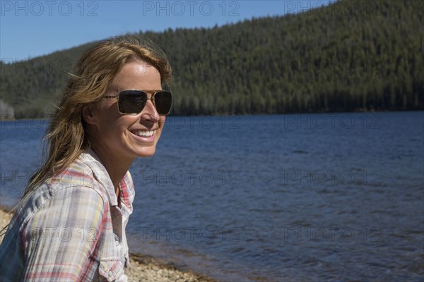 Caucasian woman sitting at remote river