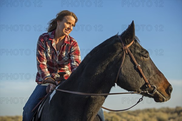 Caucasian woman riding horse