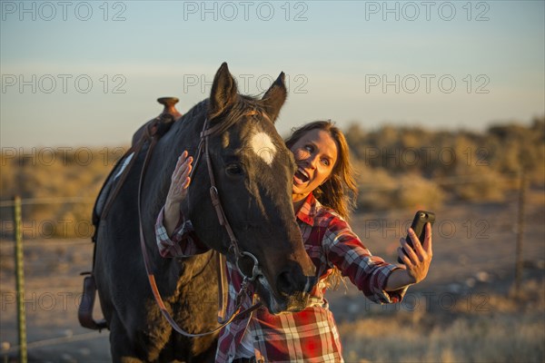 Caucasian woman taking selfie with horse