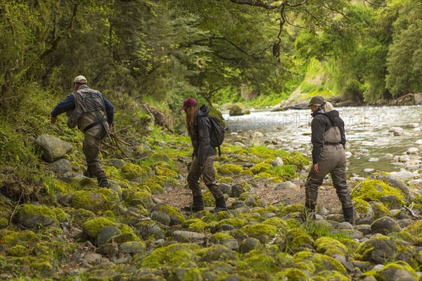 Caucasian friends walking in remote river