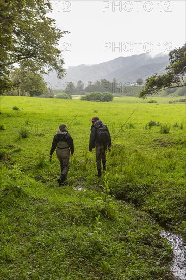 Caucasian mother and daughter walking in remote field