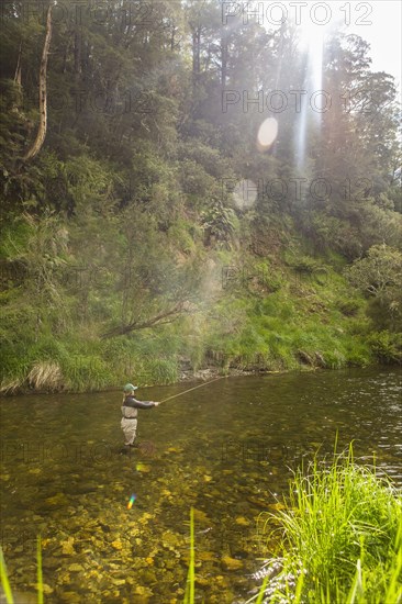 Caucasian woman fishing in remote river