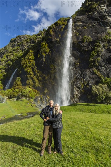 Caucasian couple hugging near remote waterfall