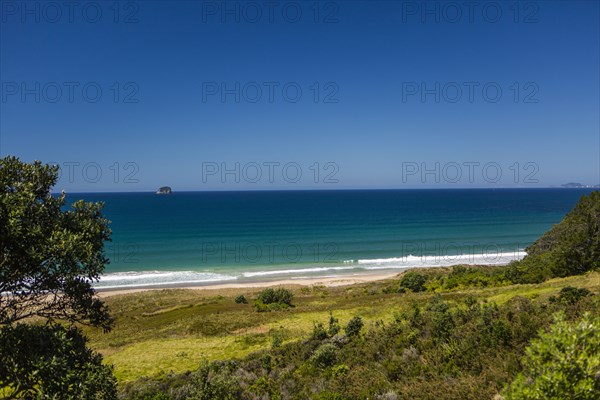 Hillside and remote beach under blue sky