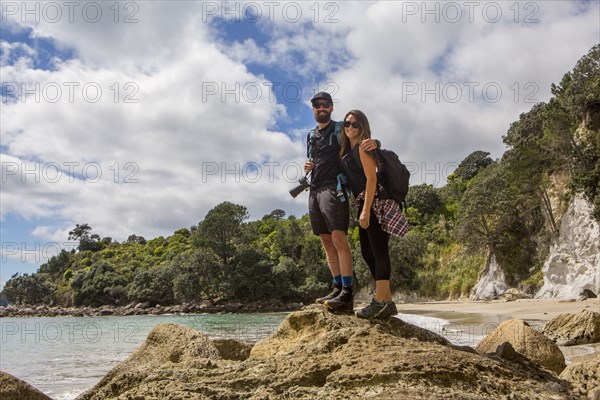 Caucasian couple hiking on remote beach