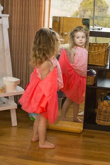 Caucasian preschooler girl playing dress-up with skirt