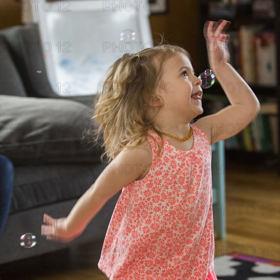 Caucasian preschooler girl playing with bubbles