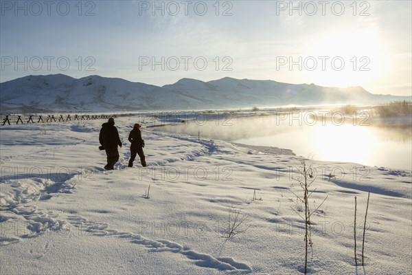 Caucasian couple walking in snowy landscape