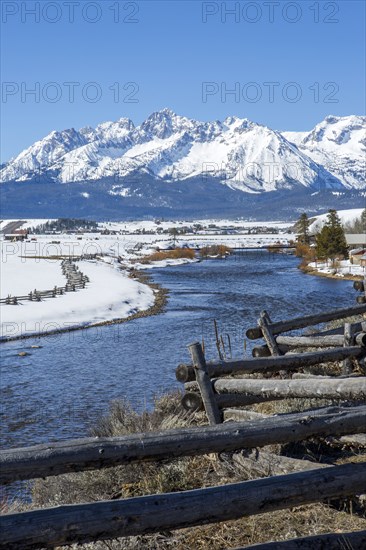 Snowy mountains and river in rural landscape