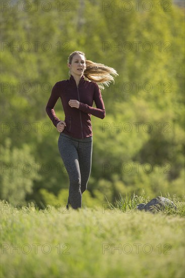 Caucasian woman running on hill