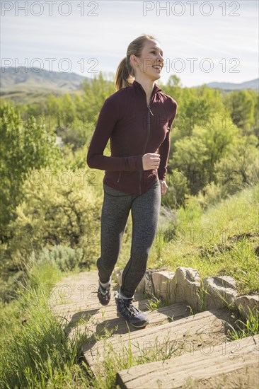 Caucasian woman running up staircase on hill