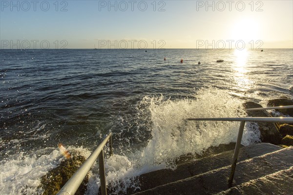 Waves splashing on staircase at ocean