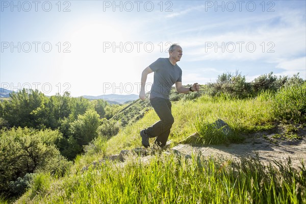 Caucasian man running up staircase on hill