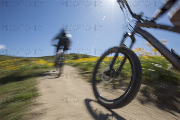 Blurred view of men riding mountain bikes