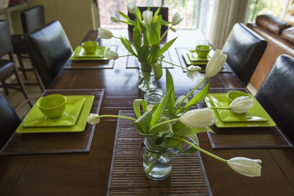 Wilting flowers in jar on dining table