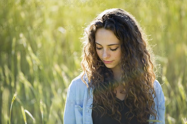 Caucasian woman standing in field of tall grass