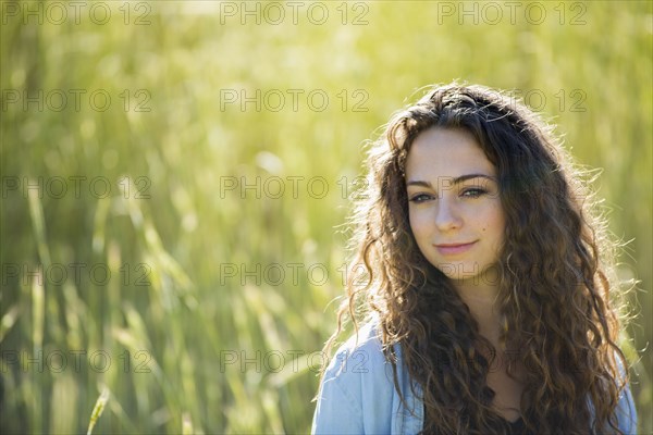 Caucasian woman standing in field of tall grass