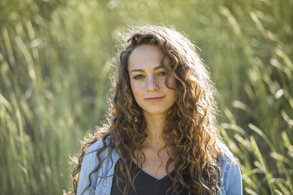 Caucasian woman standing in field of tall grass