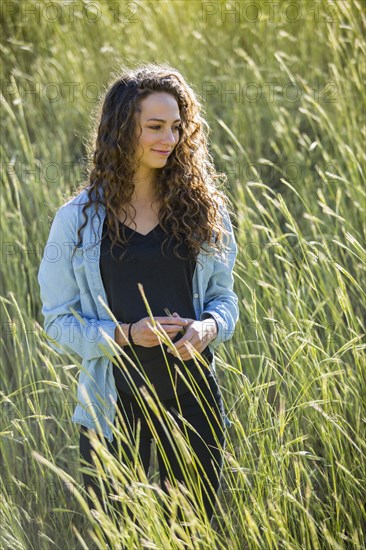 Caucasian woman standing in field of tall grass