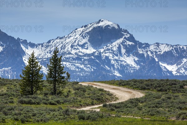 Winding dirt road near snow covered mountain range