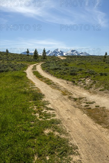 Winding dirt road near snow covered mountain range