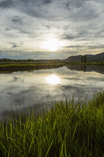 Reflection of sun in river at sunset