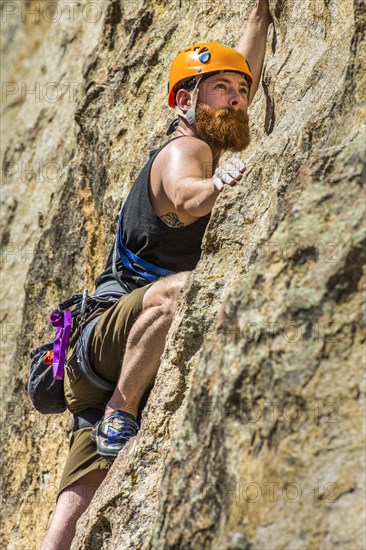 Caucasian man climbing rock