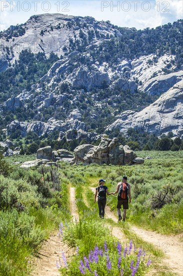 Caucasian couple hiking toward mountain